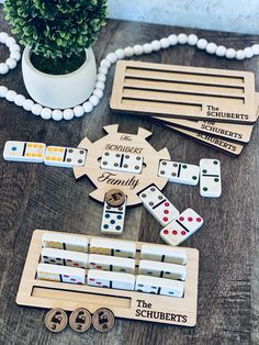 some wooden dominos are sitting on a table next to a potted plant and beads