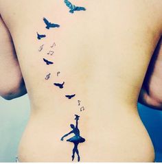 the back of a woman's stomach with birds flying over her and butterflies on it