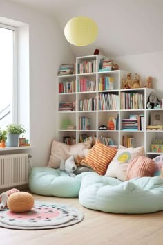 a living room filled with lots of furniture and bookshelves next to a window