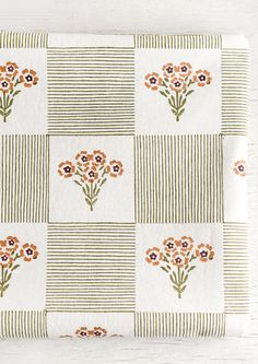 an orange and white flowered design on a checkered tablecloth with green stripes