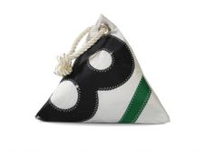 a black and white pillow with a green stripe on the bottom that has an odd shape