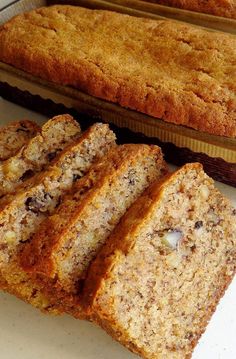 slices of banana bread sitting on top of a counter next to a loaf of cake