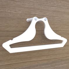 a pair of white plastic clothes hangers on a wooden surface