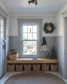 the entryway is clean and ready for guests to come home with their belongings in baskets on the bench