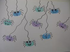 some blue and purple crabs are hanging from strings on the wall with googly eyes