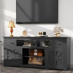 an entertainment center with a flat screen tv mounted on it's sideboard in a living room