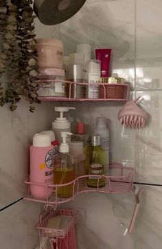 a pink shelf filled with lots of bathroom items