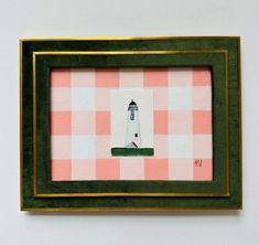 a small picture frame with a lighthouse on the top and pink gingham background