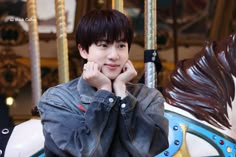 a young man sitting on top of a merry go round