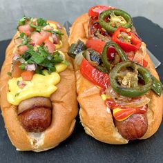 two hot dogs on buns with toppings and ketchup