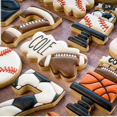 decorated cookies with baseball, basketball, and softball designs on top of a wooden table