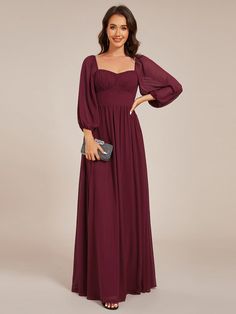 a woman wearing a long dress with sleeves on the shoulders and an open neckline