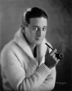 an old black and white photo of a man holding a pipe