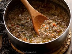 a wooden spoon in a pot filled with food