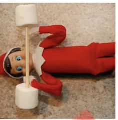 an elf is laying on the floor with marshmallows