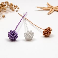 three small crocheted flowers sitting next to each other