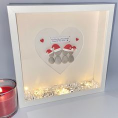 a lit up heart with two teddy bears in it and a candle next to it