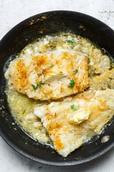 two pieces of fish are in a skillet