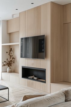 a living room with couches and a flat screen tv mounted on the side of a wall