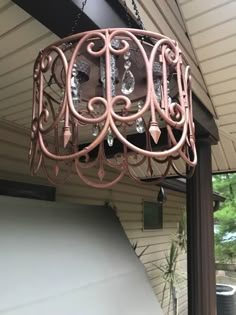 a chandelier hanging from the side of a house in front of a porch