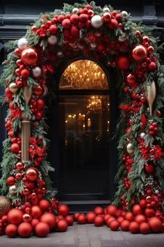 a decorated archway with red and gold ornaments on it's sides, surrounded by greenery