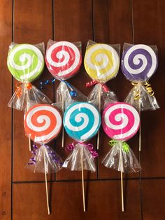 several lollipops wrapped in cellophane on a wooden table