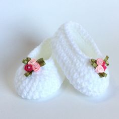 white crocheted slippers with pink flowers on them