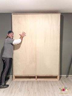 a man standing in front of a wooden closet