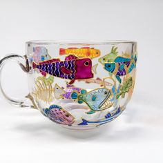 a glass cup with fish painted on it