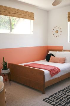 a bed room with a neatly made bed and a rug on the floor next to it