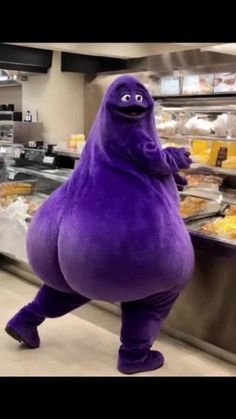 the purple monster is standing in front of some food