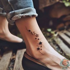 a woman's foot with stars tattoo on the side of her left leg and ankle