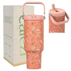 a pink insulated cup sitting next to a cardboard box with the lid open and handle extended