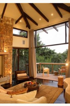 a living room filled with furniture and a fire place in front of a large window