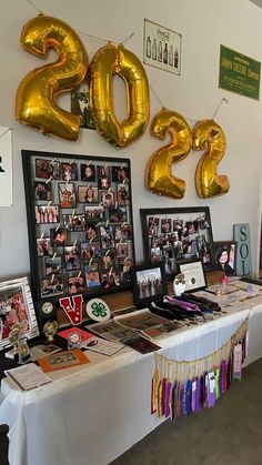 a table topped with pictures and balloons in the shape of numbers