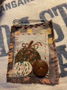 a close up of a piece of cloth with a button on it and a pin in the middle