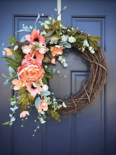 a wreath with flowers hanging on the front door