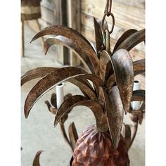 a metal pineapple hanging from a chandelier