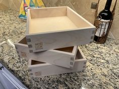 three wine boxes stacked on top of each other in the middle of a kitchen counter