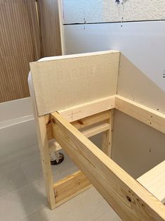 an unfinished wooden bench sitting in the middle of a room next to a bathtub