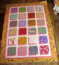 a quilt is laying on the floor next to a table