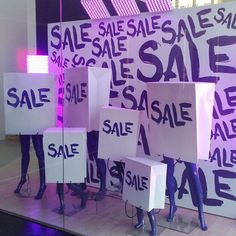 several mannequins holding up signs in front of a purple background that says sale