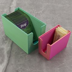 a green and pink box with two compartments filled with coffee beans next to each other