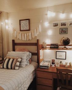 a bedroom with a bed, desk and pictures on the wall