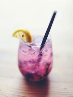 a purple drink with lemon wedges in it