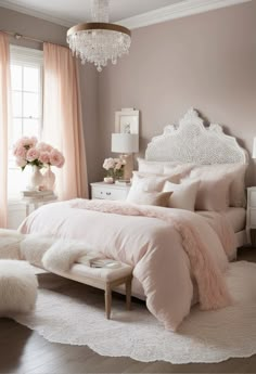 a bedroom with pink and white bedding, chandelier, rugs and windows