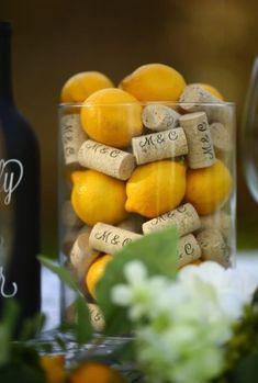 wine corks and oranges in a glass vase