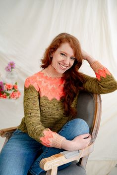 a woman sitting in a chair with her hands on her head and smiling at the camera