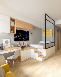 a bedroom with a bed, desk and stairs leading to another room that has a large window