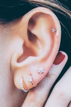 a close up of a person wearing an ear with two piercings on their ears